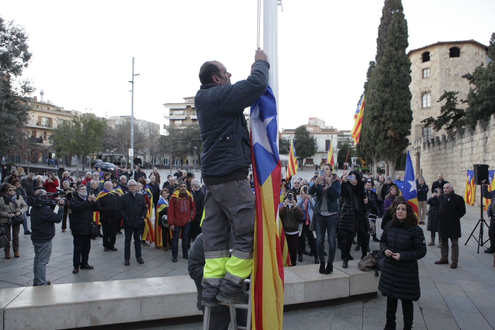 Un operari de la brigada baixant l'estelada i l'alcaldessa a la dreta FOTO: Artur RIbera