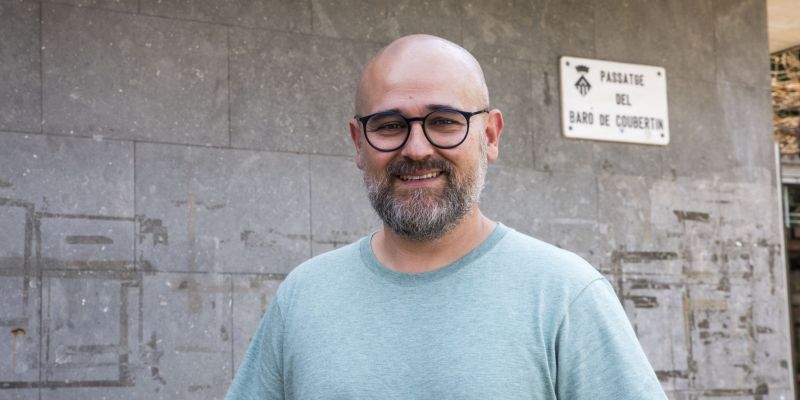 El periodista Marc Martín amb la placa del passatge del Baró de Coubertin, creador dels Jocs Olímpics moderns. FOTO: Bernat Millet (TOT Sant Cugat)